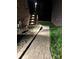 Backyard walkway and stairs leading to a deck at night, with stone and landscaping at 1422 Spring Ridge Ln, Denver, NC 28037