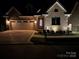 Night view of a lovely brick home with a two-car garage, professionally landscaped yard, and exterior lighting at 1422 Spring Ridge Ln, Denver, NC 28037