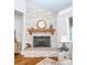 Elegant corner fireplace with stone surround and wooden mantel in living room at 1422 Spring Ridge Ln, Denver, NC 28037