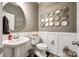 Modern powder room with a pedestal sink, toilet, and decorative mirror at 1968 Sapphire Meadow Dr, Fort Mill, SC 29715