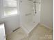 Bathroom featuring walk-in shower, grab bar, and marble-look tile floor at 2823 Edsel Pl, Charlotte, NC 28205