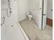 Clean bathroom with shower, toilet, and vanity featuring marble-look tile floors at 2823 Edsel Pl, Charlotte, NC 28205