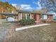 Charming brick home features a covered carport, garden, and inviting front porch at 2823 Edsel Pl, Charlotte, NC 28205