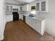 Updated kitchen with white cabinets, modern appliances, and ample counter space with warm wood floors at 2823 Edsel Pl, Charlotte, NC 28205