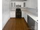 Kitchen area showcasing white cabinetry with glass panels and black gas range at 2823 Edsel Pl, Charlotte, NC 28205