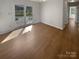 Spacious room featuring hardwood floors, neutral walls, and a door leading to an outdoor area at 2823 Edsel Pl, Charlotte, NC 28205