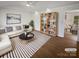 Bright living room featuring a white sofa, striped rug, and custom bookcase with warm wood floors at 2823 Edsel Pl, Charlotte, NC 28205