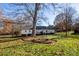 Back exterior of the home with a deck, lawn and mature trees at 3309 E Broad St, Statesville, NC 28625