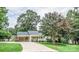 Charming one-story home boasts a covered carport, inviting front porch, and mature landscaping at 3309 E Broad St, Statesville, NC 28625