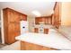 Bright kitchen with white appliances, wood cabinets, and laminate countertops at 3309 E Broad St, Statesville, NC 28625