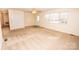 Empty living room with neutral carpet, a front door, and several windows at 3309 E Broad St, Statesville, NC 28625