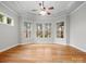 Sunlit bedroom showcasing large windows with backyard views, a ceiling fan, and hardwood floors at 4104 Granite Cir, Indian Land, SC 29707