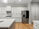 Charming kitchen with white cabinetry, stainless steel refrigerator, hardwood floors, and stylish tile backsplash at 4104 Granite Cir, Indian Land, SC 29707