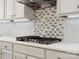 Detailed view of the kitchen's stovetop, backsplash, and white countertops at 4104 Granite Cir, Indian Land, SC 29707