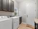 Functional laundry room with washer, dryer, storage cabinets, and tiled floors at 4104 Granite Cir, Indian Land, SC 29707