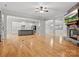 Open living room with hardwood floors, stone fireplace, and seamless connection to the kitchen at 4104 Granite Cir, Indian Land, SC 29707