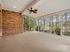 Spacious sunroom with brick accent wall, carpet floors, ceiling fan and panoramic views of the backyard at 4104 Granite Cir, Indian Land, SC 29707