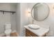 Elegant bathroom with a pedestal sink, decorative vessel sink, and a round mirror at 419 Sylvania Ave, Charlotte, NC 28206