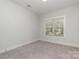 Bright bedroom with a window and neutral walls and carpeting at 419 Sylvania Ave, Charlotte, NC 28206