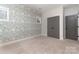 Bedroom with gray wave patterned wall, carpet, and double doors at 419 Sylvania Ave, Charlotte, NC 28206