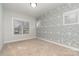 Spacious bedroom with wave-patterned wallpaper and neutral carpeting at 419 Sylvania Ave, Charlotte, NC 28206