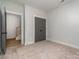 Simple bedroom with gray doors and neutral-colored carpet at 419 Sylvania Ave, Charlotte, NC 28206