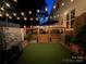 Backyard deck at night with string lights, seating area, and artificial turf at 711 Torrey Pines Ln, Fort Mill, SC 29715