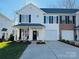 Two-story townhome with white siding, black shutters, and a small front porch at 711 Torrey Pines Ln, Fort Mill, SC 29715