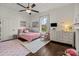 Bright bedroom with a ceiling fan, light walls, and a pink bed at 110 College St, Marshville, NC 28103