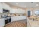 Modern kitchen with stainless steel appliances, white cabinets, and granite countertops at 1878 Sapphire Meadow Dr, Fort Mill, SC 29715