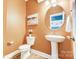 Powder room with pedestal sink and orange walls at 3001 Burton Point Ct, Waxhaw, NC 28173