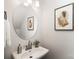 Powder room with round mirror, pedestal sink, and tasteful artwork at 3118 Amay James Ave, Charlotte, NC 28208