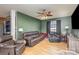 Living room with leather furniture, ceiling fan, and a green accent wall at 410 E Louisiana Ave # 2, Bessemer City, NC 28016