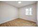 Bright bedroom with hardwood floors, fresh white paint and a single window with natural light at 4328 Hancock Ter, Charlotte, NC 28205