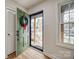 Bright entryway featuring a green front door, hardwood floors, and closet at 4328 Hancock Ter, Charlotte, NC 28205