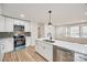 Modern kitchen featuring white cabinets, a stainless steel oven, and a large island with quartz countertops at 4328 Hancock Ter, Charlotte, NC 28205