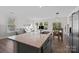 Kitchen island with stone countertop and a view of the stainless steel refrigerator, dining area and living room at 620 Altamonte Dr, Clover, SC 29710