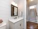 Charming bathroom featuring a white vanity, mirror, and staircase at 1012 Rockway Dr, Charlotte, NC 28205