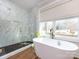 Luxurious bathroom featuring a freestanding tub, marble shower and wood floors at 1012 Rockway Dr, Charlotte, NC 28205