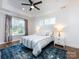 Bright bedroom with a tray ceiling, ceiling fan, large window, and a luxurious bed with stylish linens and pillows at 1012 Rockway Dr, Charlotte, NC 28205