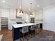 Kitchen featuring a large kitchen island with seating, modern pendant lighting, and stainless steel appliances at 1012 Rockway Dr, Charlotte, NC 28205
