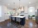 Kitchen featuring a large kitchen island with seating, modern pendant lighting, and stainless steel appliances at 1012 Rockway Dr, Charlotte, NC 28205