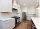 Kitchen featuring white cabinets, stainless steel appliances, quartz countertops, and a modern range hood at 1012 Rockway Dr, Charlotte, NC 28205