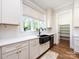 Modern kitchen with white cabinets, quartz countertops, stainless steel appliances, and a farmhouse sink at 1012 Rockway Dr, Charlotte, NC 28205