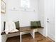 Mudroom featuring a wooden bench, white walls, coat hooks, green decorative pillows, and a small window at 1012 Rockway Dr, Charlotte, NC 28205