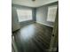 Bright bedroom featuring wood-look flooring, two windows for natural light, and freshly painted walls at 2801 Cowles Rd, Charlotte, NC 28208