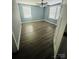 Spacious bedroom featuring wood-look flooring, ceiling fan, two windows, and fresh neutral paint at 2801 Cowles Rd, Charlotte, NC 28208