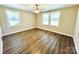Large bedroom featuring two large windows, wood-look flooring, ceiling fan, and fresh neutral paint at 2801 Cowles Rd, Charlotte, NC 28208