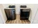 Bright laundry area with side-by-side washer and dryer, wood-look flooring, and fresh white paint at 2801 Cowles Rd, Charlotte, NC 28208
