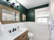 Clean bathroom with green walls, white tile, and a wood vanity at 3315 Eastwood Dr, Charlotte, NC 28205